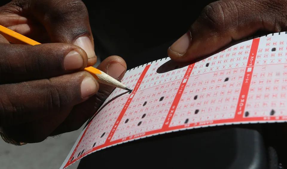 Person filling out a lottery ticket.