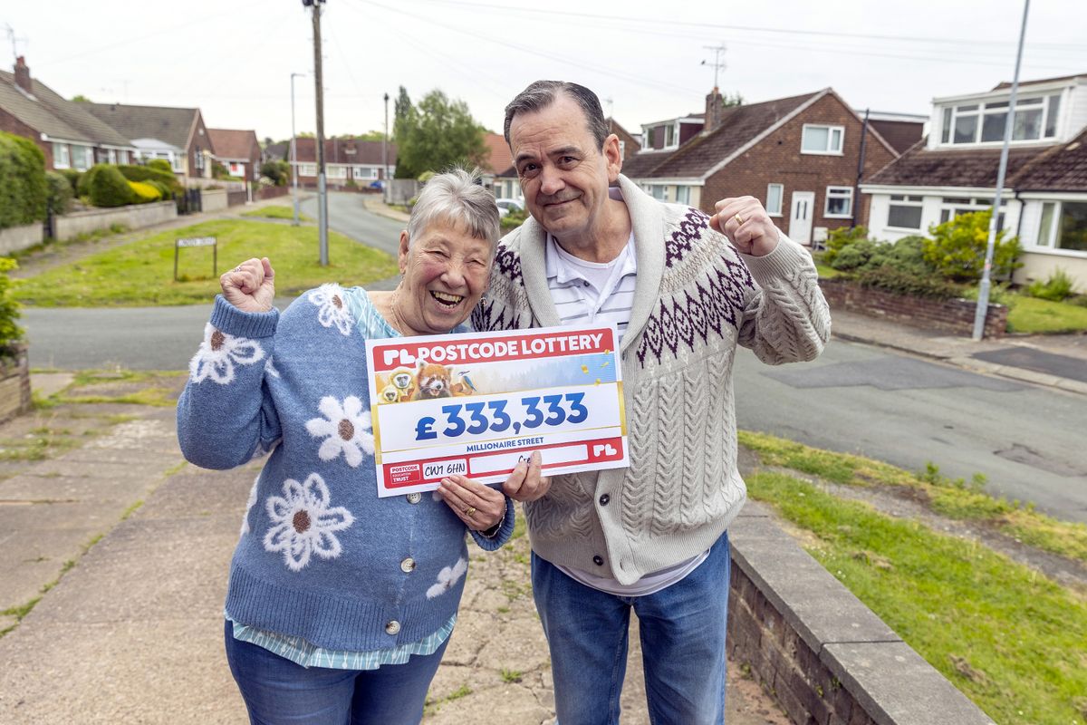 Nancy Barkley and her husband, Colin, holding a large cheque celebrating their £333,333 win