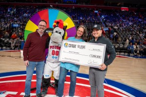 Acting Lottery Commissioner, Joe Froehlich, presents Sarah Tawwater and her husband, Andrew, with $1 million check