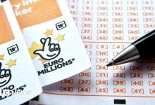 Two EuroMillions tickets side-by-side, with the National Lottery logo seen at the top of both, beside a ballpoint pen