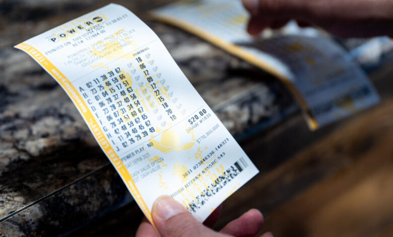 A person holds Powerball lottery tickets they purchased at the Brew Market & Cafe on September ...
