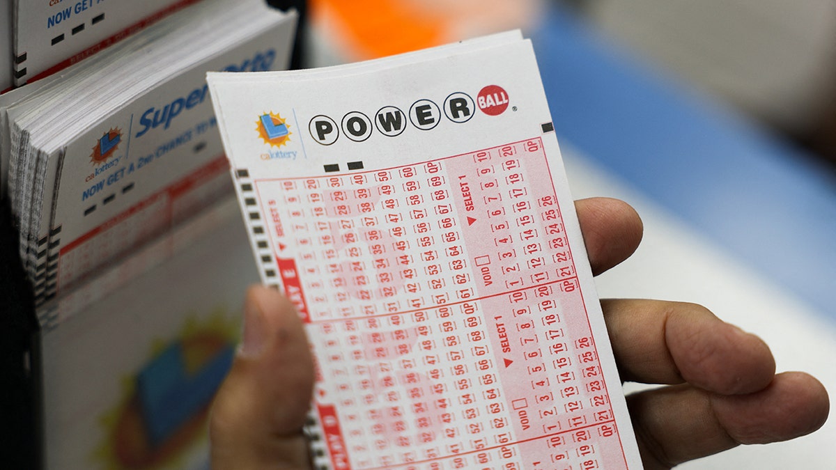 hand holding a powerball lottery ticket