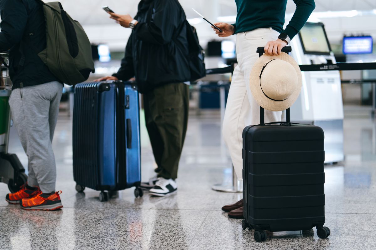 General photo of airline passengers with suitcases standing in queue