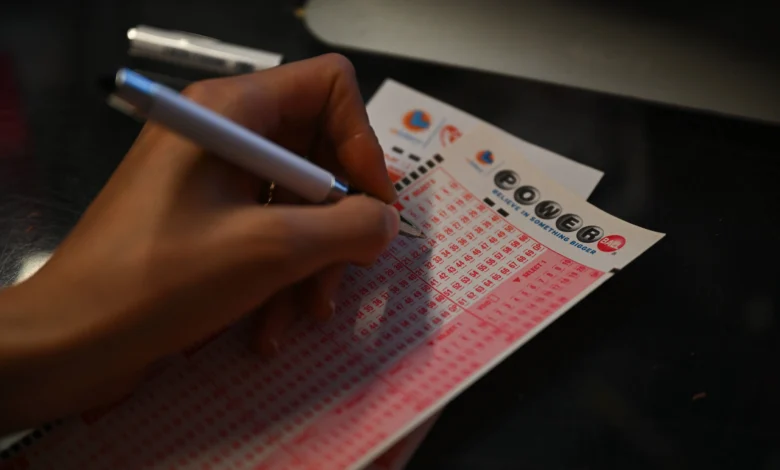 A person plays lottery at a store as US Powerball jackpot grand prize grew to a whopping $1 billion after no ticket got all six numbers in San Mateo, California - Source: Getty