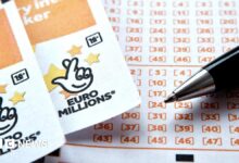Two EuroMillions tickets side-by-side, with the National Lottery logo seen at the top of both, beside a ballpoint pen