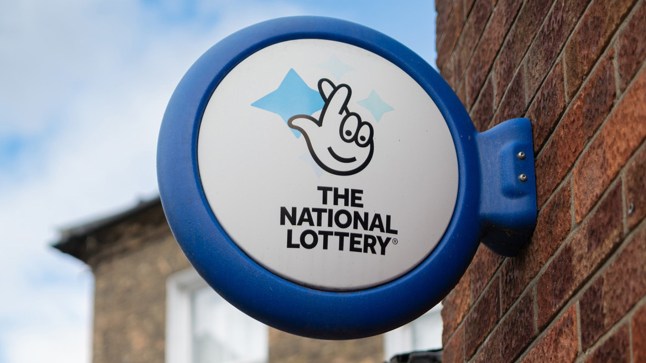 Southwold, Suffolk, UK - 4 October 2023: British Lottery Gambling sign seen outside a newsagent. The sign is attached to an old brick wall in the seaside town. The sign is made of ABS plastic.; Shutterstock ID 2380928023; purchase_order: -; job: -; client: -; other: -
