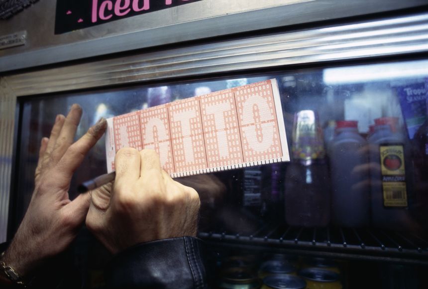 A man writes on his lotto ticket at Ohan Cigarette Store in hopes of winning the $60 million lottery in New York on October 27, 1994.