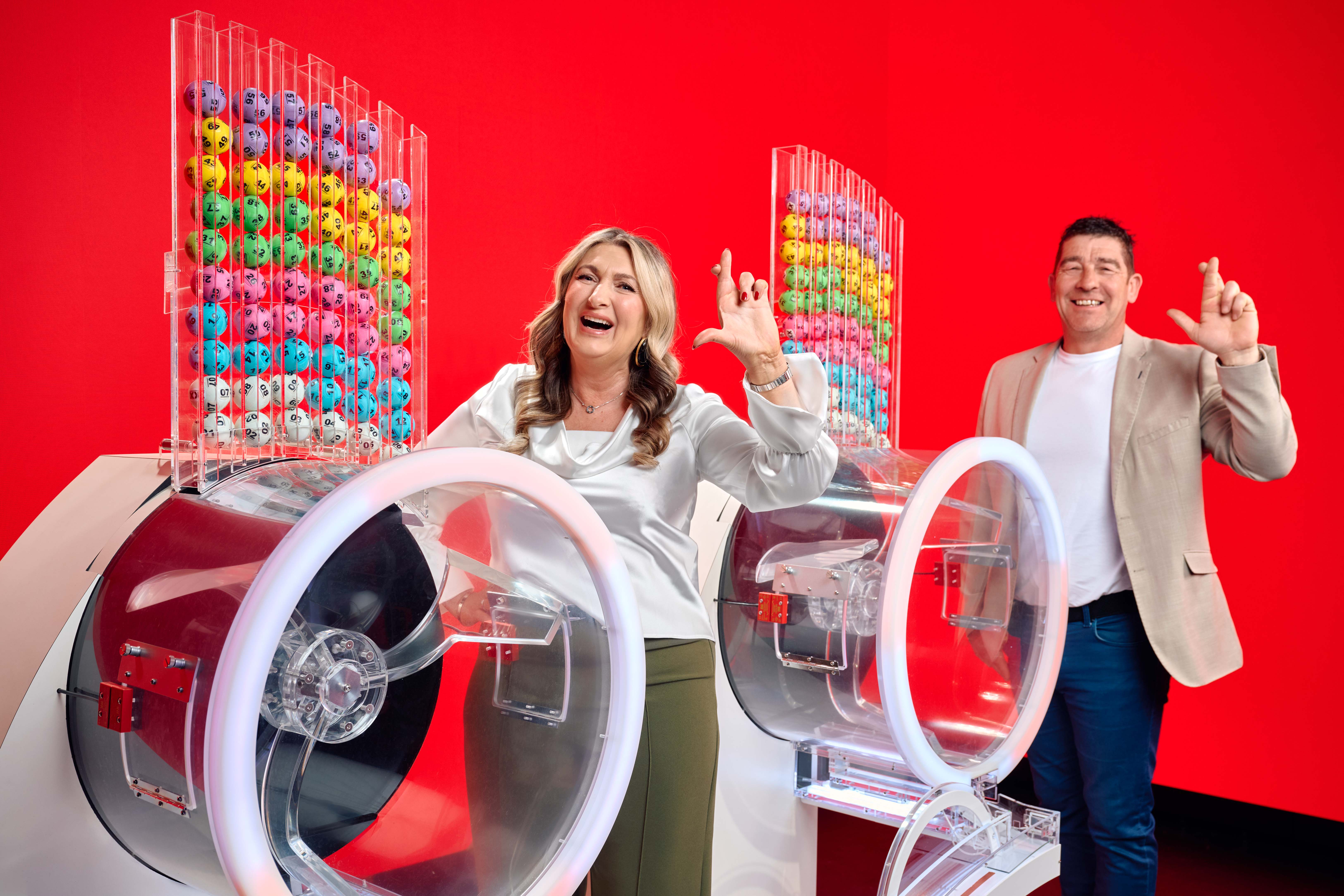 Chris and Geraldine Bradley, who won £3.57M on Lotto in 2006, alongside the two Lotto draw machines to mark the new two-round format