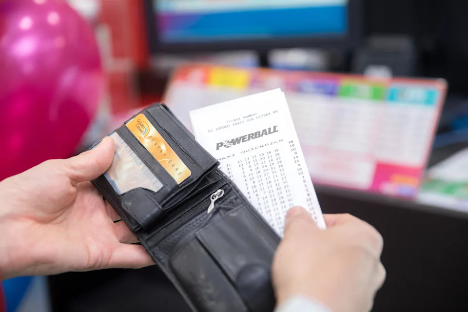 A Powerball Quickpick ticket being removed from a wallet.