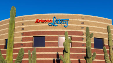 a building with the arizona lottery logo on it, with saguaro cacti in front