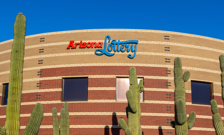 a building with the arizona lottery logo on it, with saguaro cacti in front