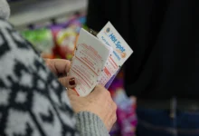Hawthorne, CA - December 1: Ellen Adelman waits in line with her lottery tickets at Bluebird Liquor on Monday, Dec. 1, 2025 in Hawthorne, CA. Adelman and her husband William have been playing the lottery at Bluebird Liquor for years.  (Juliana Yamada / Los Angeles Times via Getty Images)