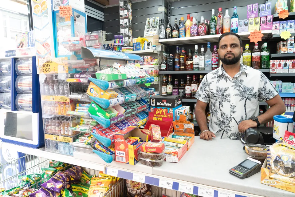 Karan Kumar, who sold a 12 million pound winning lottery ticket, standing behind the counter of a Londis convenience store.
