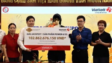 A Korean lottery winner, center, poses after claiming the top prize in Vietnam
