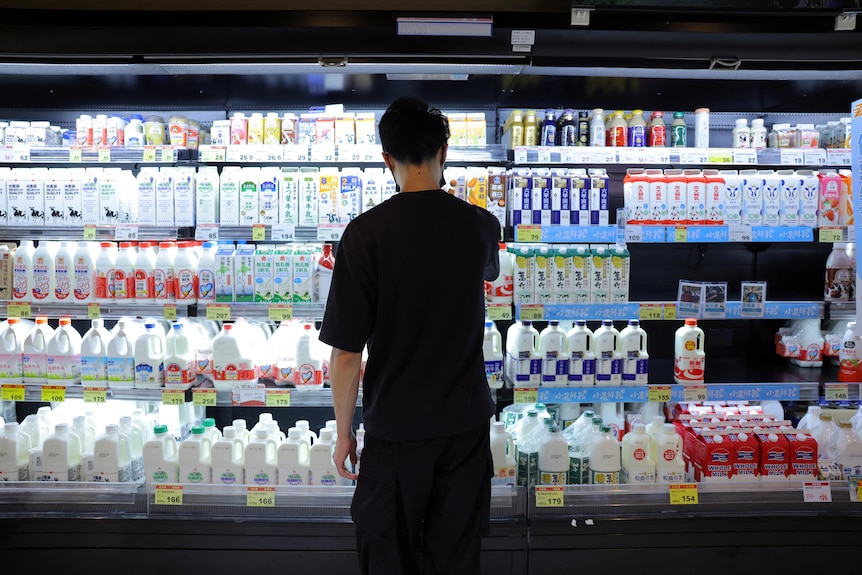 A customer stands in front of dairy products displayed on a shelf at a PX Mart supermarket in Taipei.