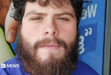 Photo of Jake Davison. He has curly dark hair and a brown bushy beard. He is looking into the camera.