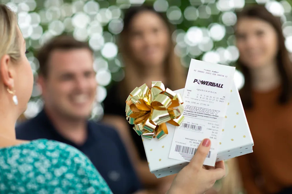 Woman holding Powerball tickets.